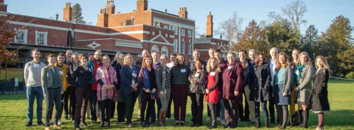 the 32 participants are gathered outside in front of Hinxton Hall