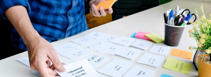 Stock photo of a person arranging sticky notes in an office environment
